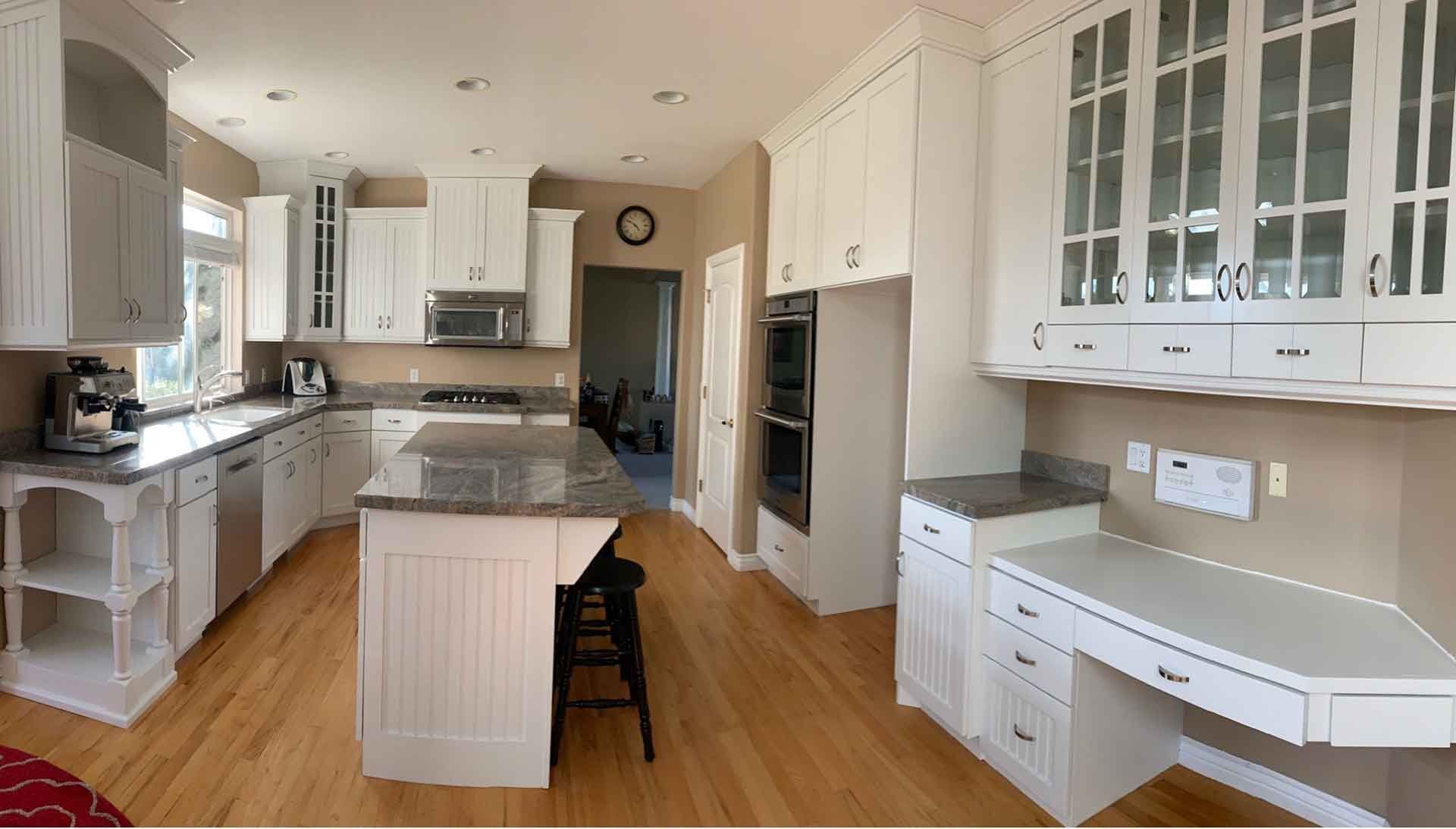 A kitchen with white cabinets and stainless steel appliances