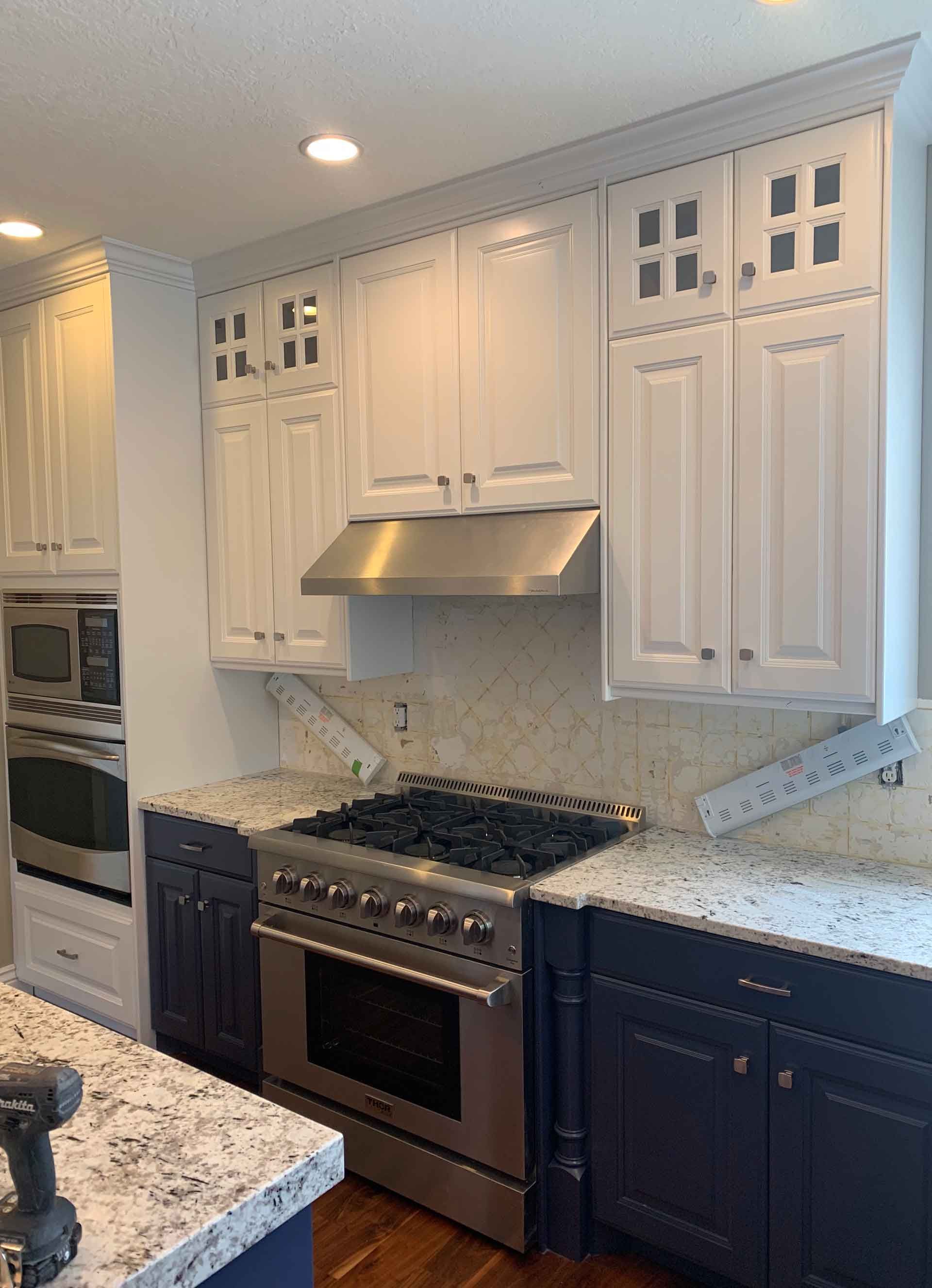 A kitchen with white cabinets and stainless steel appliances.