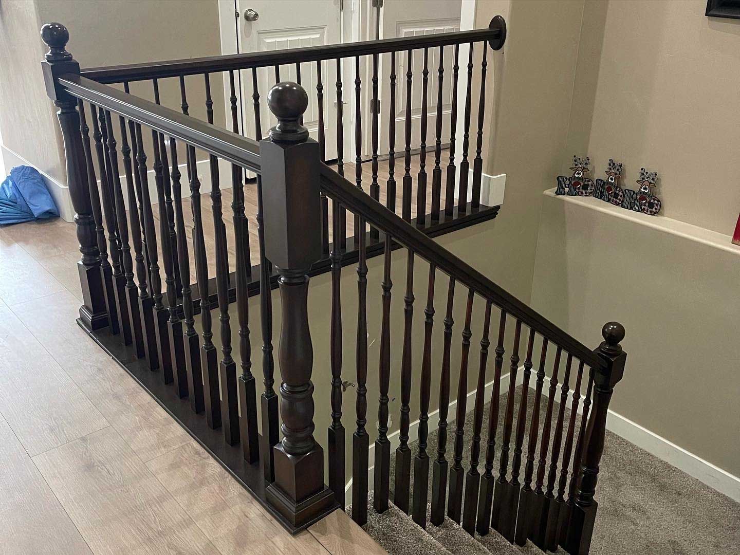 A wooden staircase with a black railing in a house.