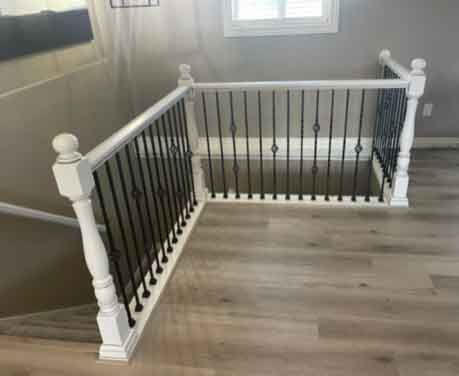 A staircase with a white railing and a black railing in a house.
