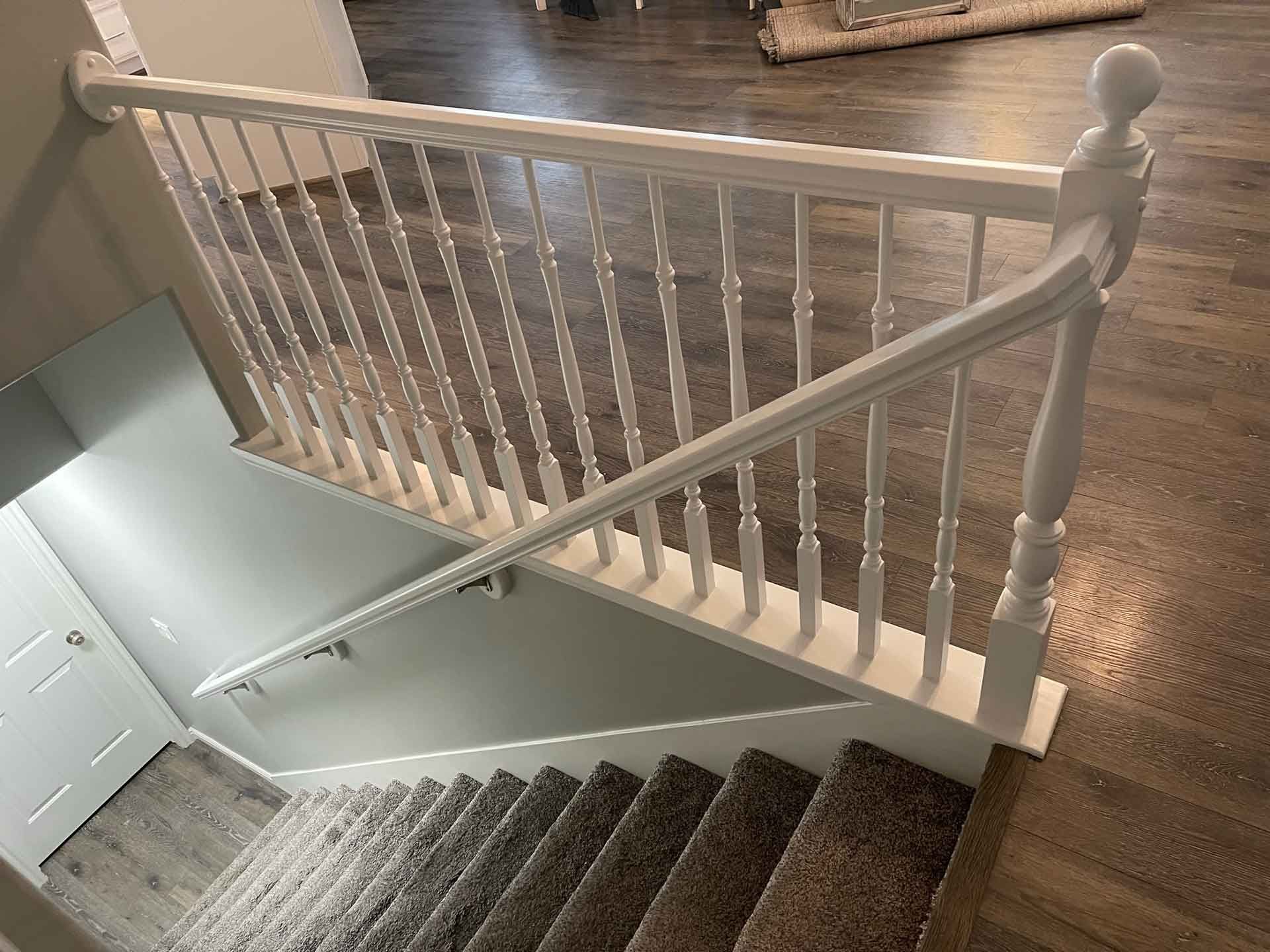 A white railing on a set of stairs in a house.