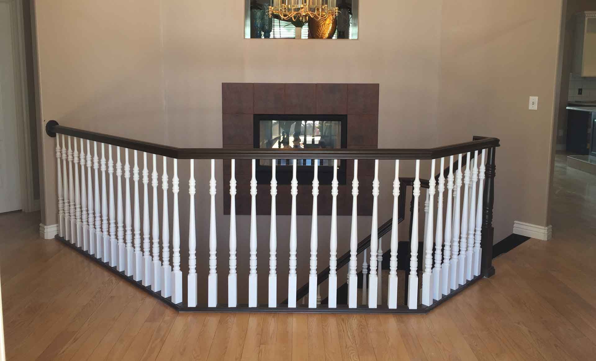 A living room with a fireplace and stairs with a white railing.