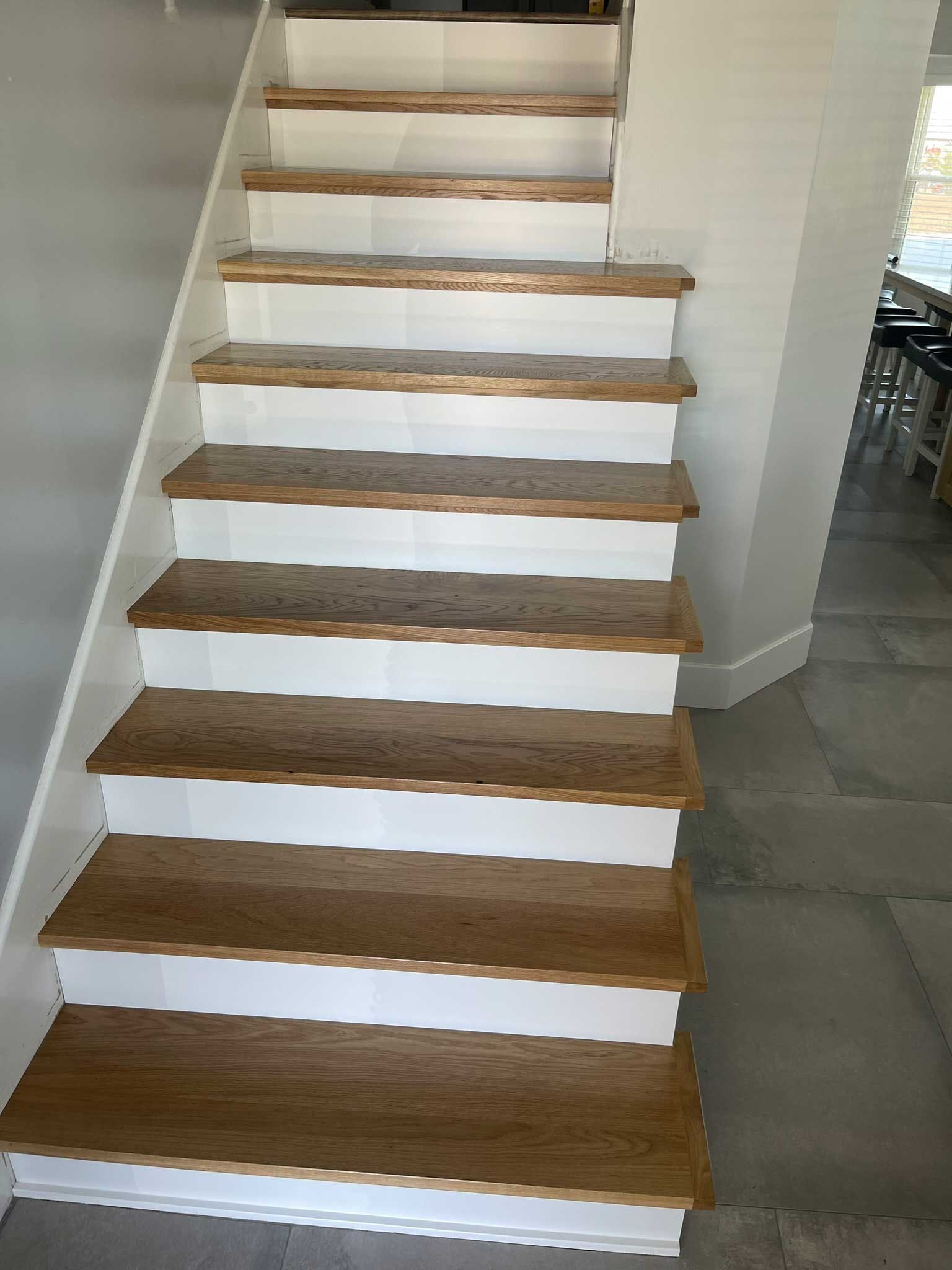 A staircase with wooden steps and white steps in a house.