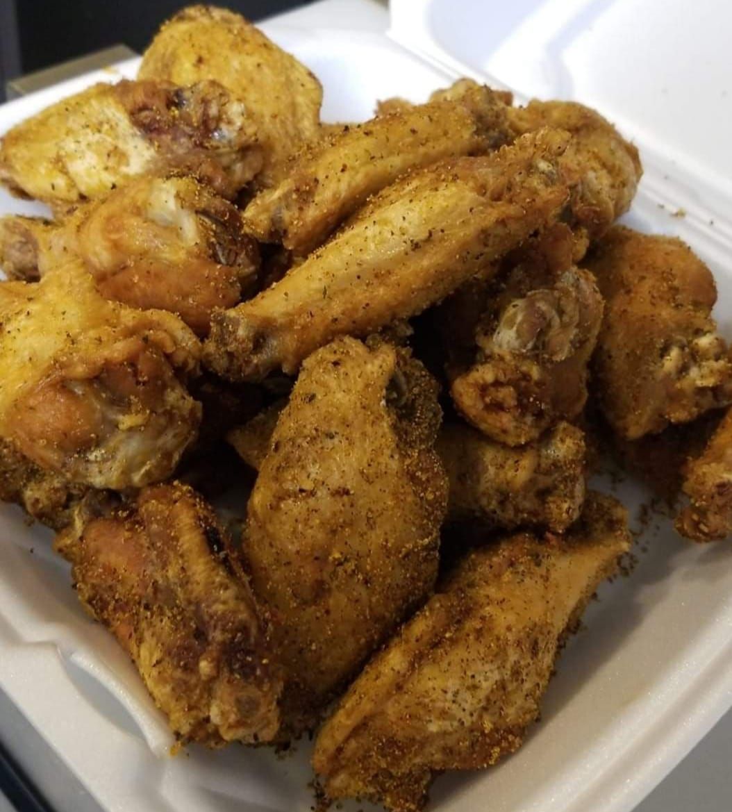 Tacos on a plate with margarita and shot glass on wooden table.