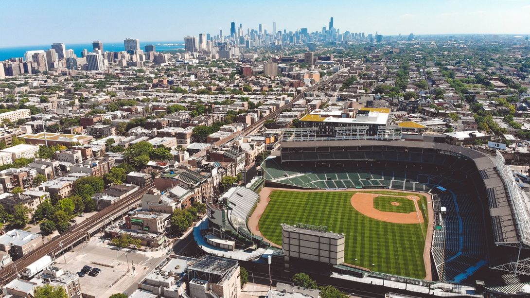 An aerial view of a baseball stadium with a city in the background.