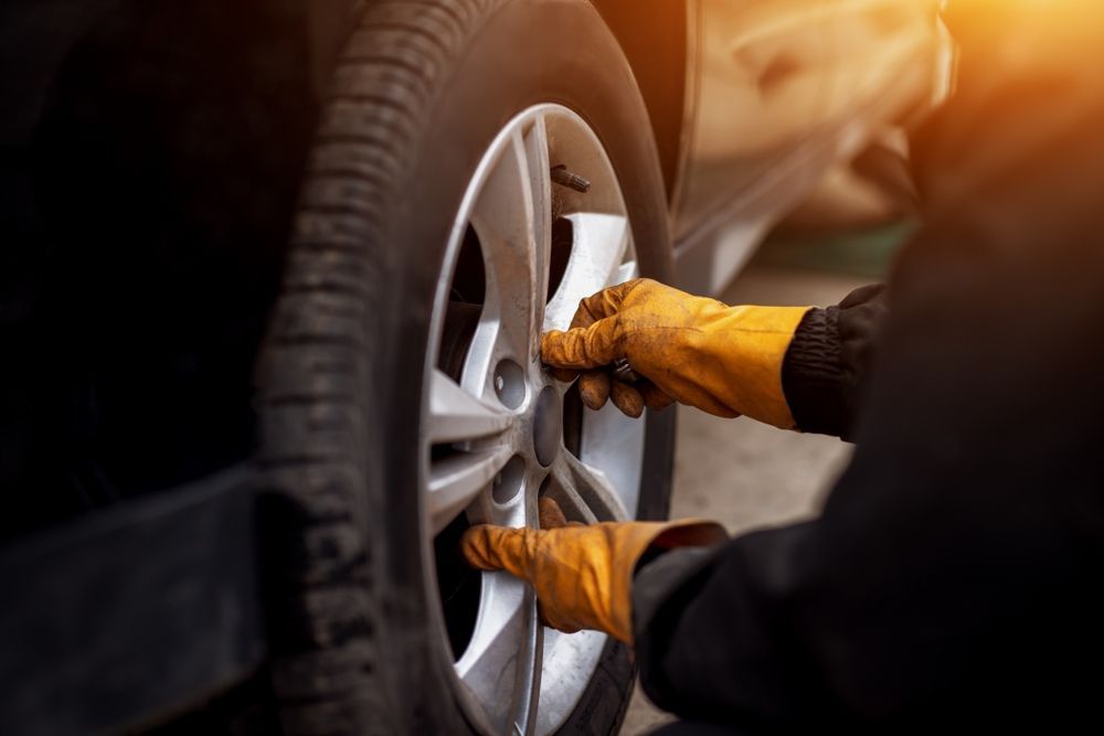 A Person Is Changing A Tire On A Car — East Lismore Automotive in East Lismore, NSW