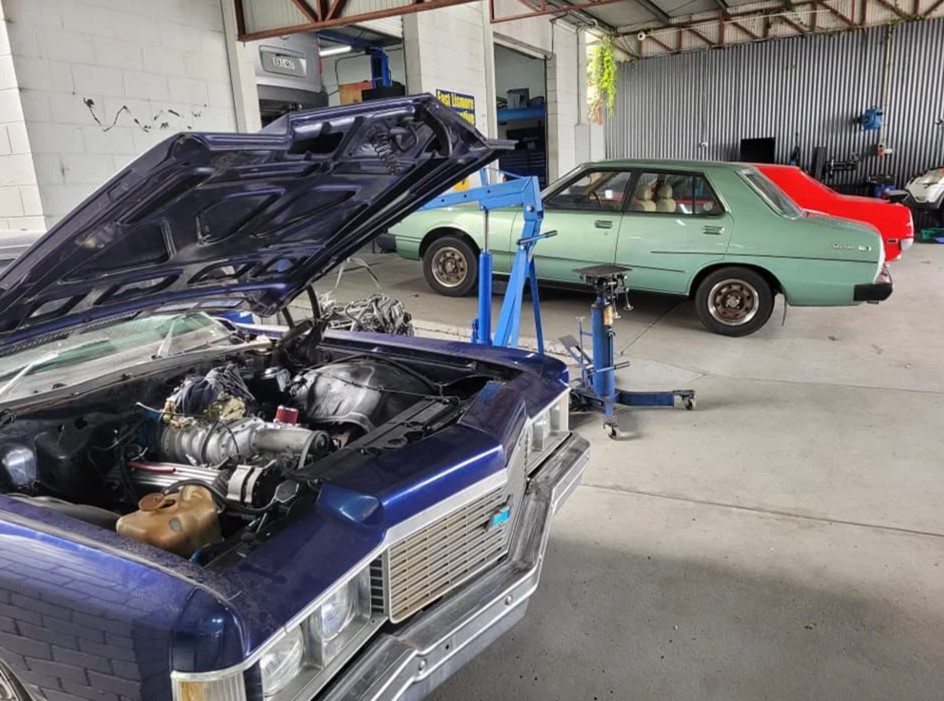 A Dark blue car is parked in workshop with bonnet open — East Lismore Automotive in East Lismore, NSW
