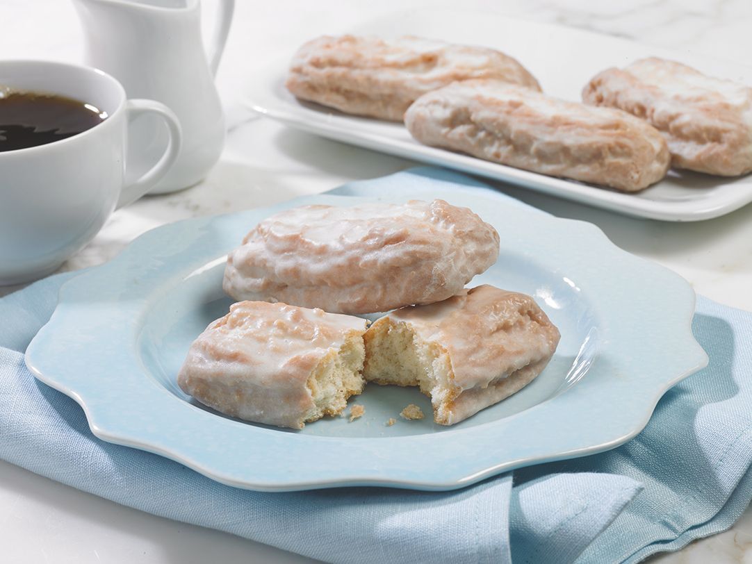 A plate of donuts with a bite taken out of one of them