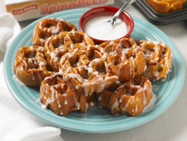 a plate of pecan spinwheels as waffles drizzled with icing on a blue plate