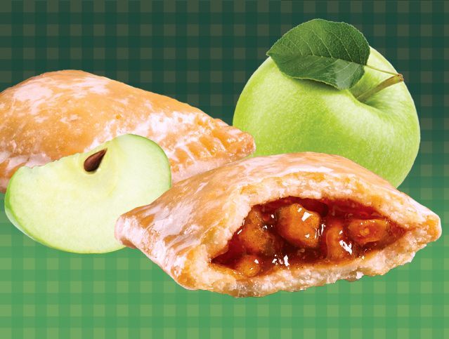 An apple pie with a green apple in the background