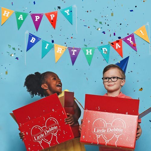 A boy and a girl are holding boxes that say little debbie on them.