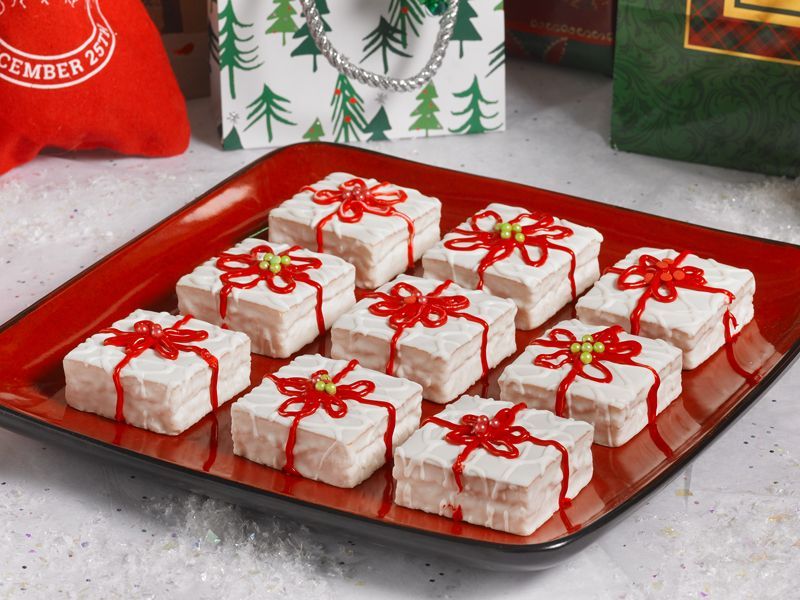A red plate topped with white squares decorated to look like presents