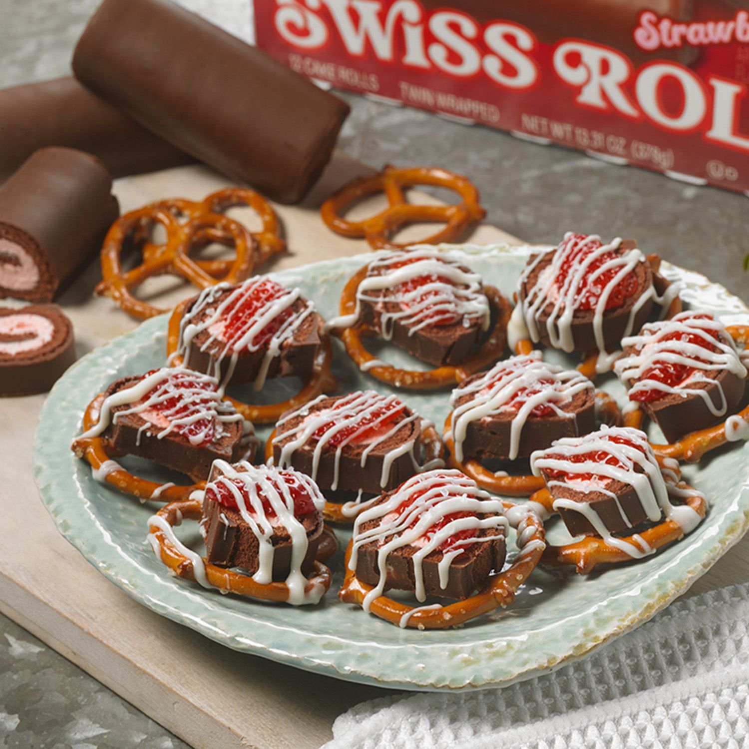 A plate of swiss roll pretzels with strawberries on top