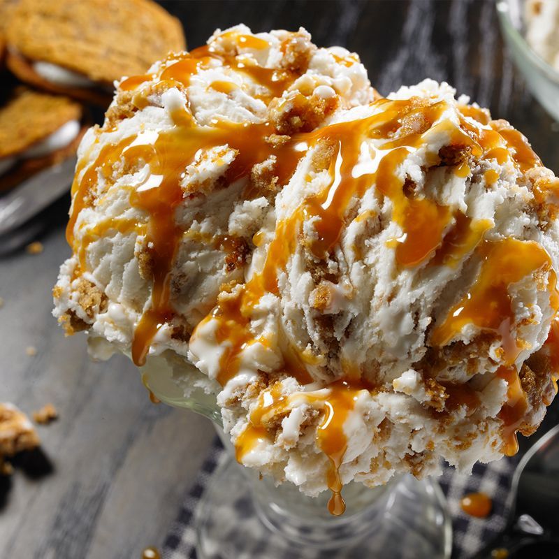 A glass of ice cream with caramel sauce on top