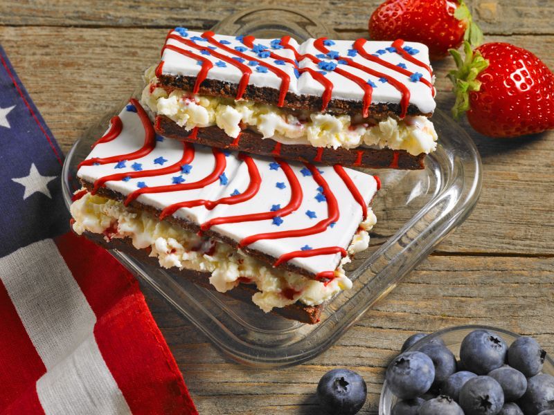 Two slices of cake with red white and blue frosting on a glass plate
