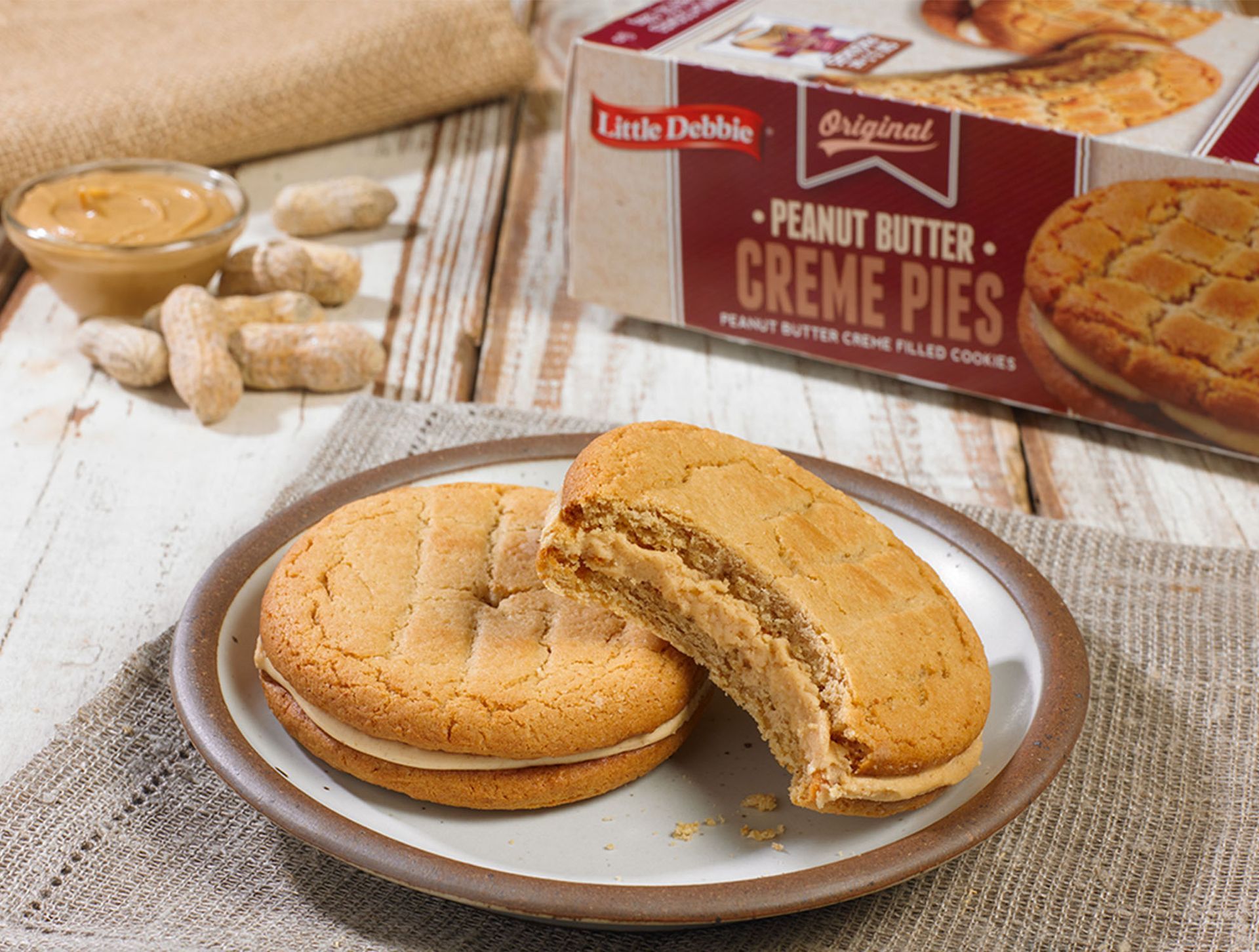 Two peanut butter creme pies on a plate next to a box