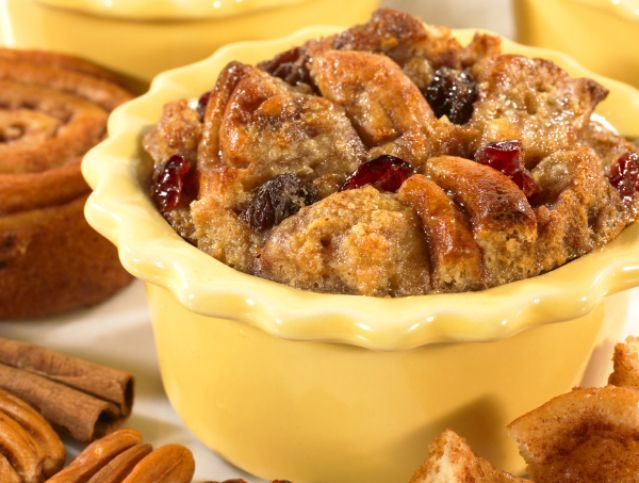 A bowl of bread pudding with cranberries and pecans