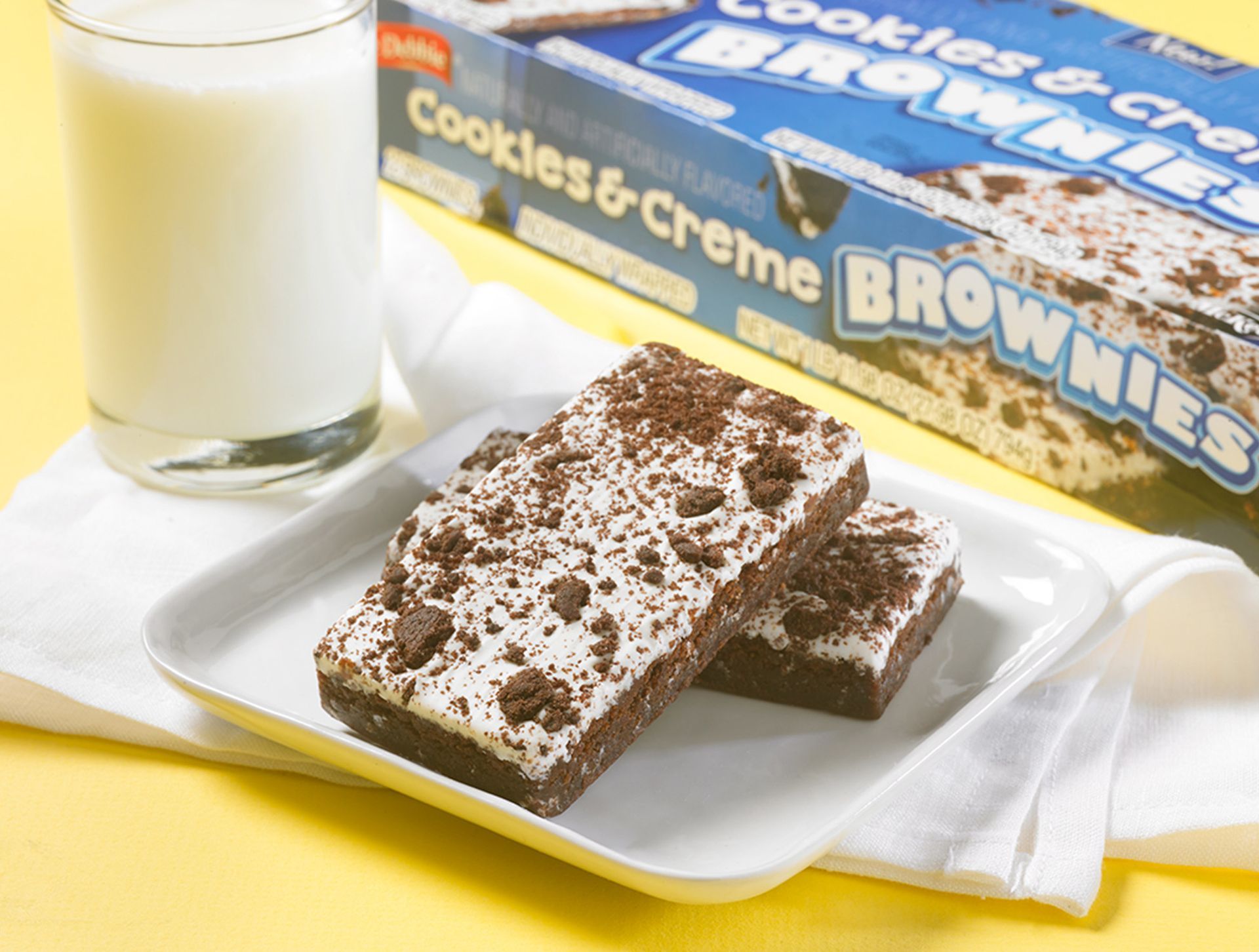 A box of cookies and creme brownies next to a glass of milk