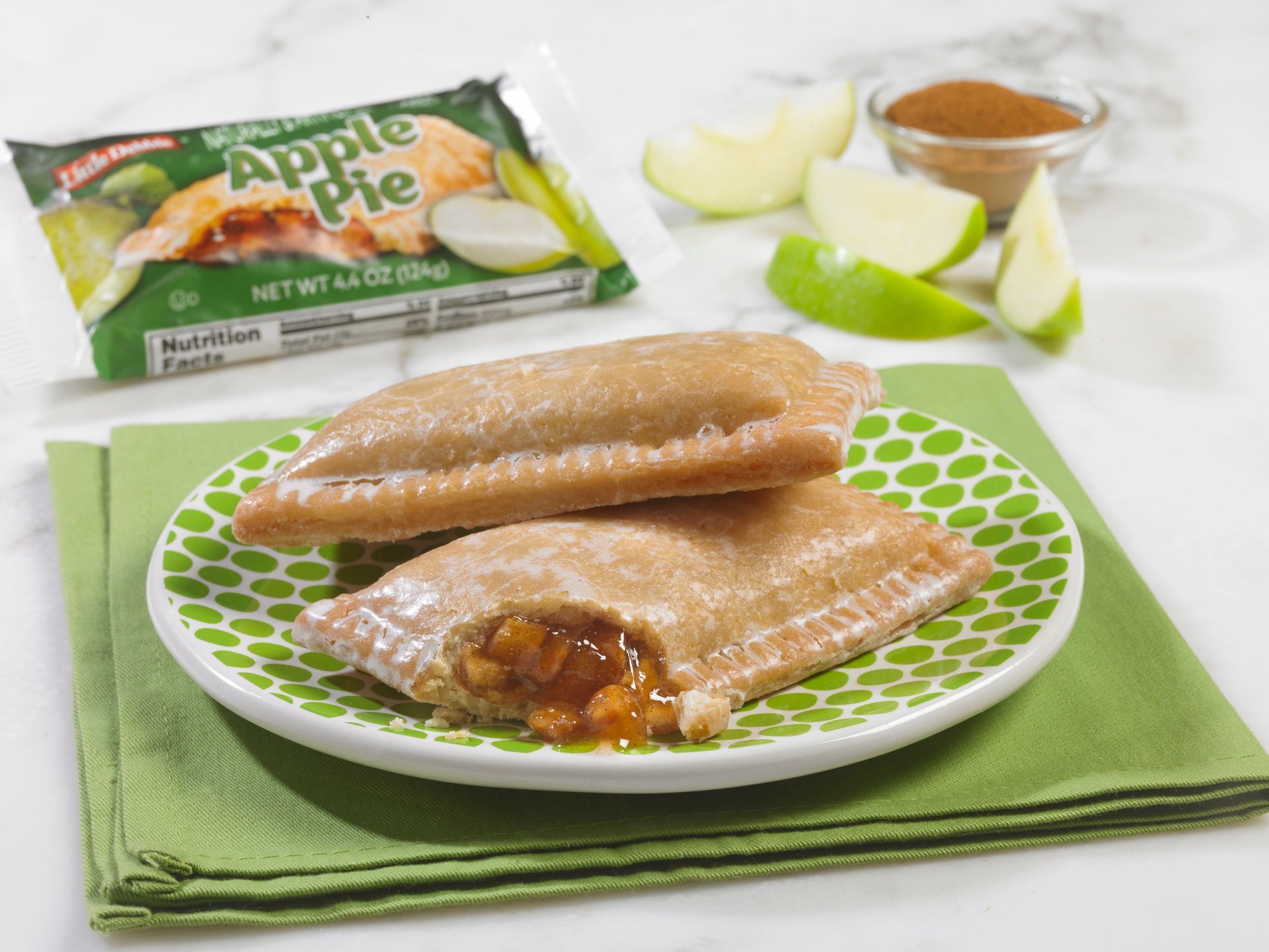 An apple pie with a green apple in the background