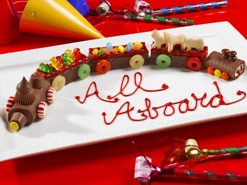 A white plate with a chocolate train and the words all aboard written on it
