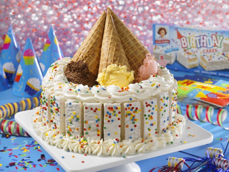 A birthday cake with ice cream cones and sprinkles on top