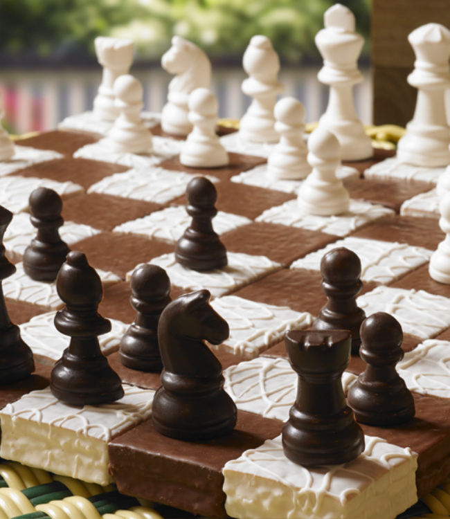 devil squares and fancy cakes laid as a chess board with chess candies
