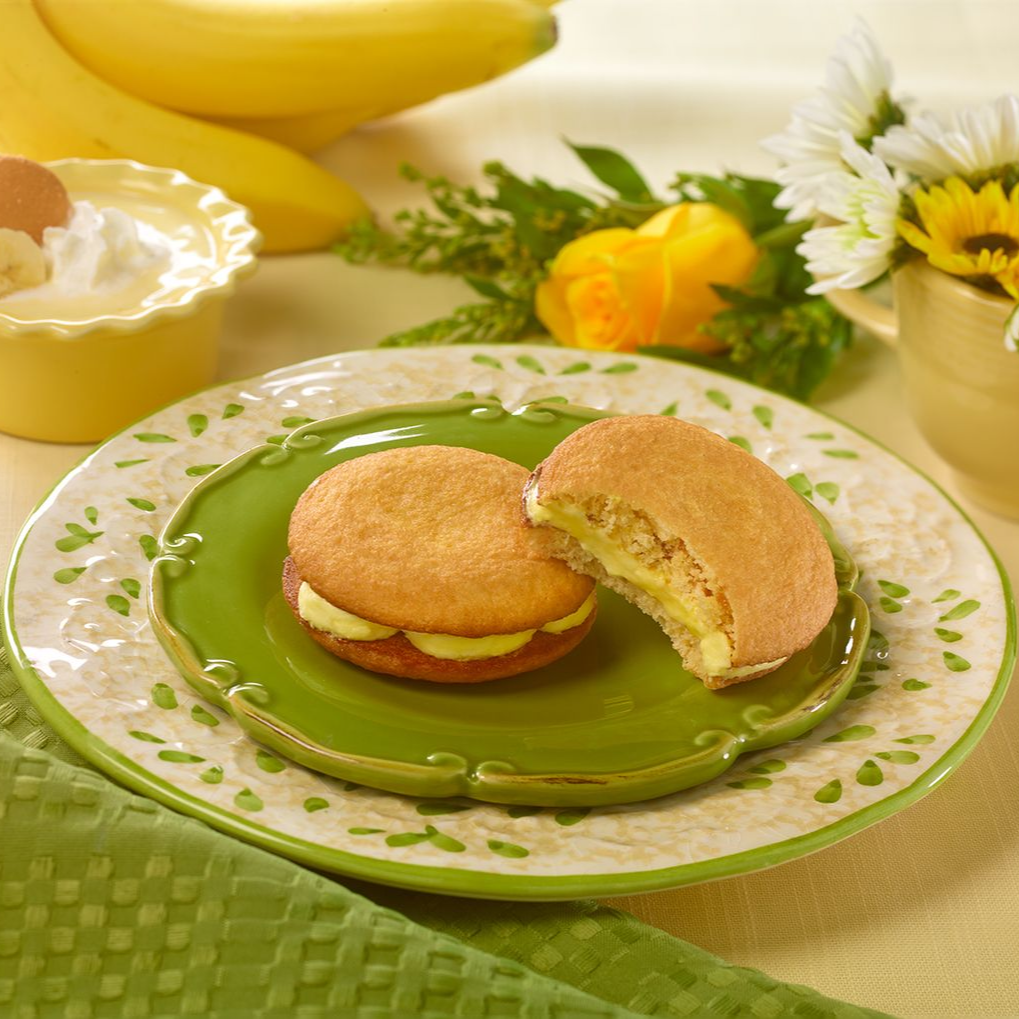 two banana puddin creme pies on a green plate with one missing a bite