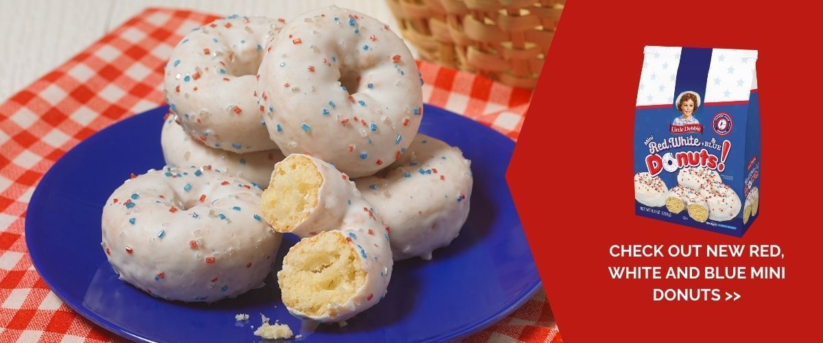 A blue plate topped with white donuts with red white and blue sprinkles