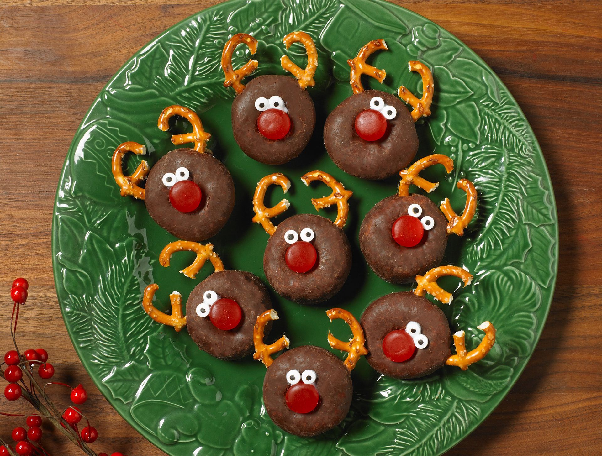A green plate topped with chocolate reindeer cookies and pretzels