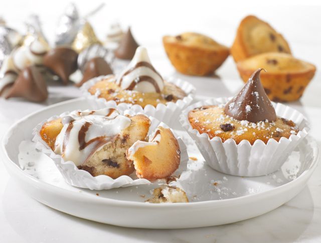 A white plate topped with cupcakes and chocolate kisses