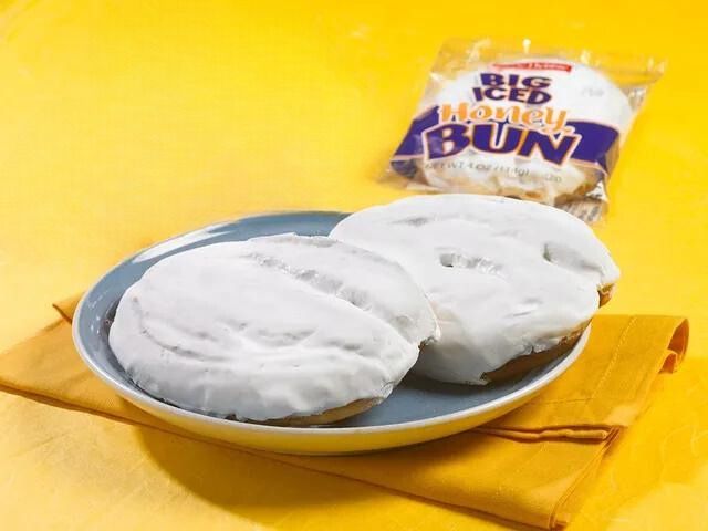 A bag of big iced monkey buns sits next to a plate of buns