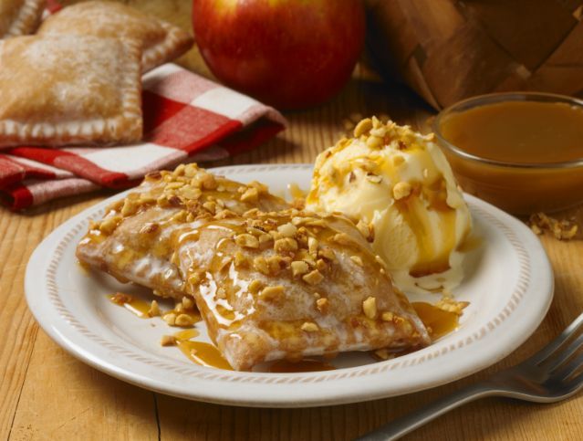 A white plate topped with apple pie and ice cream