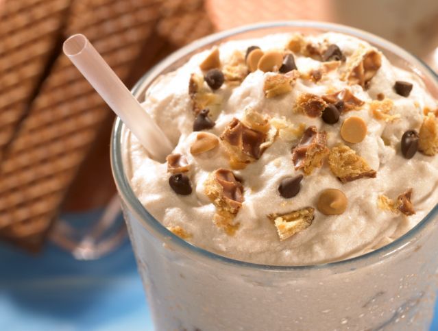 A milkshake with whipped cream and chocolate chips on top