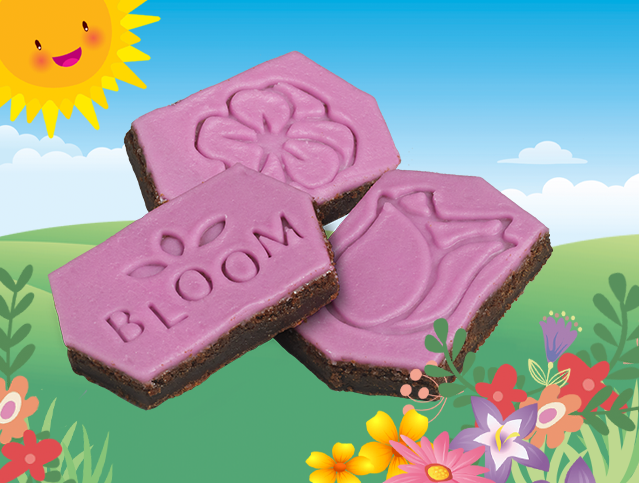 Three purple cookies with the word bloom on them