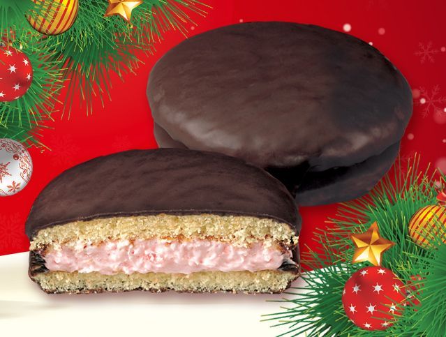 A cookie with a strawberry filling is surrounded by christmas decorations
