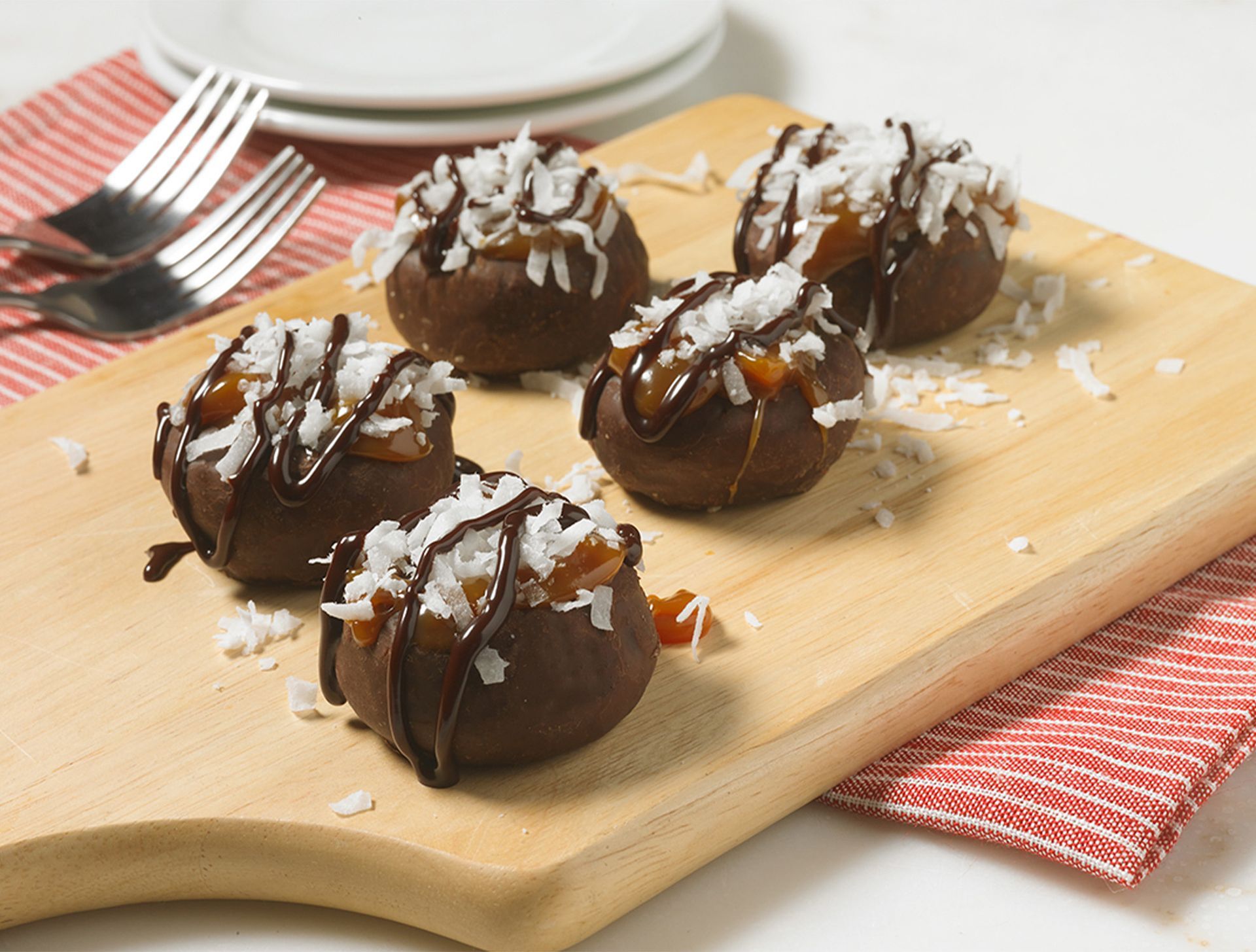 A wooden cutting board topped with chocolate and coconut