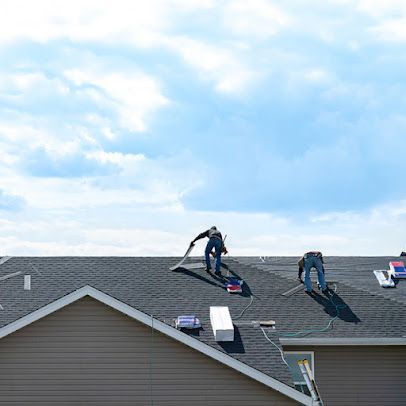 Two men are working on the roof of a house.