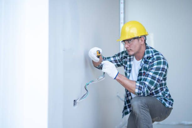 Electrician wiring electrical system in new residence.
