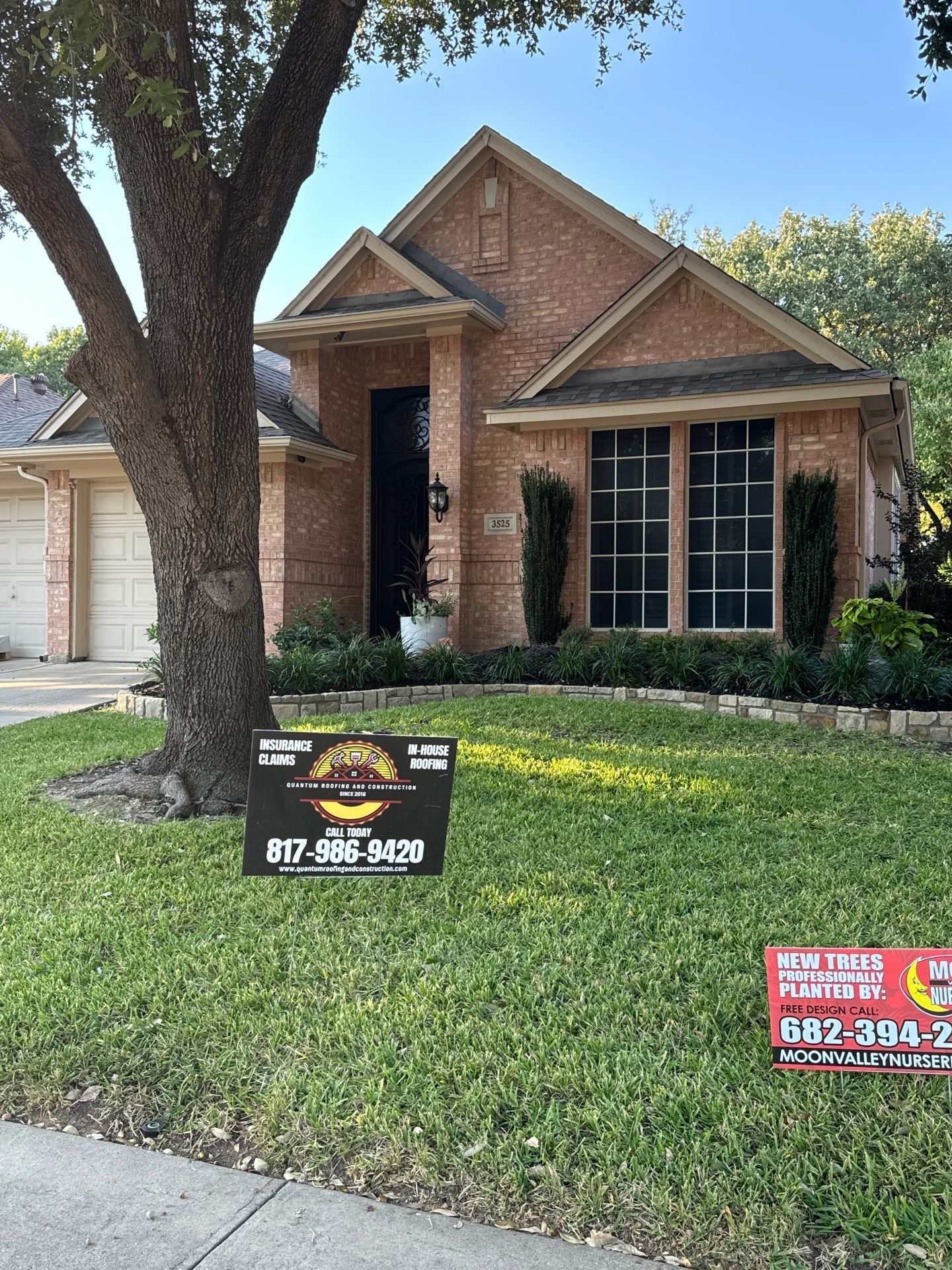 A brick house with a for sale sign in front of it.
