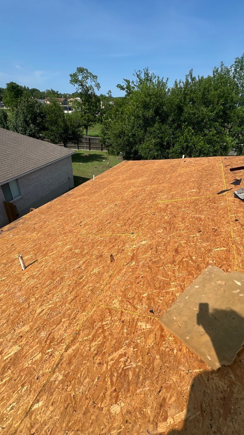The roof of a house is being covered with plywood.