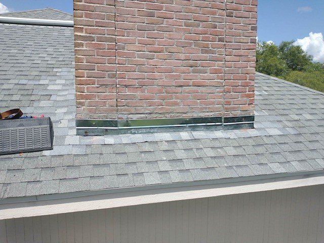 A roof with a brick chimney on top of it