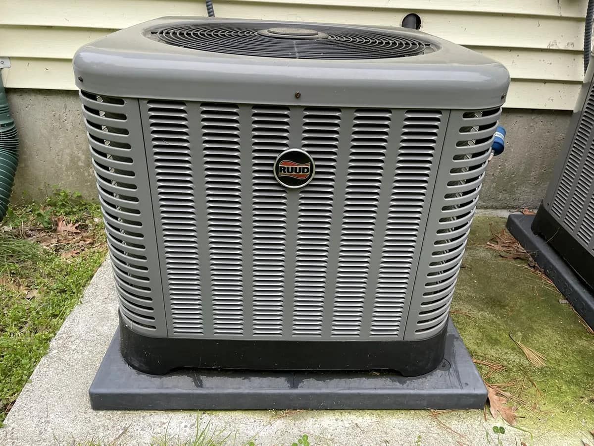 A large air conditioner is sitting on top of a concrete platform.