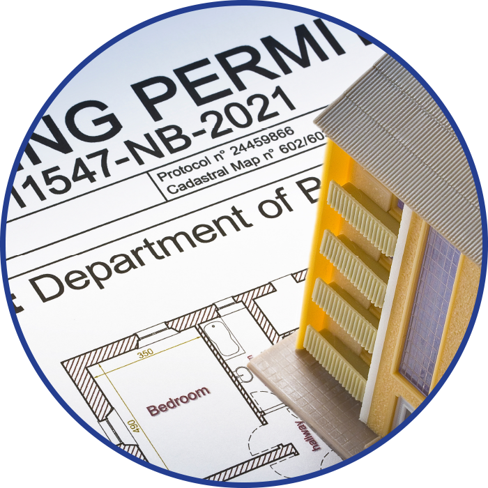 Building permit and miniature building model with a blueprint.