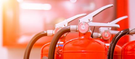 Red fire extinguishers in a row, ready for use.