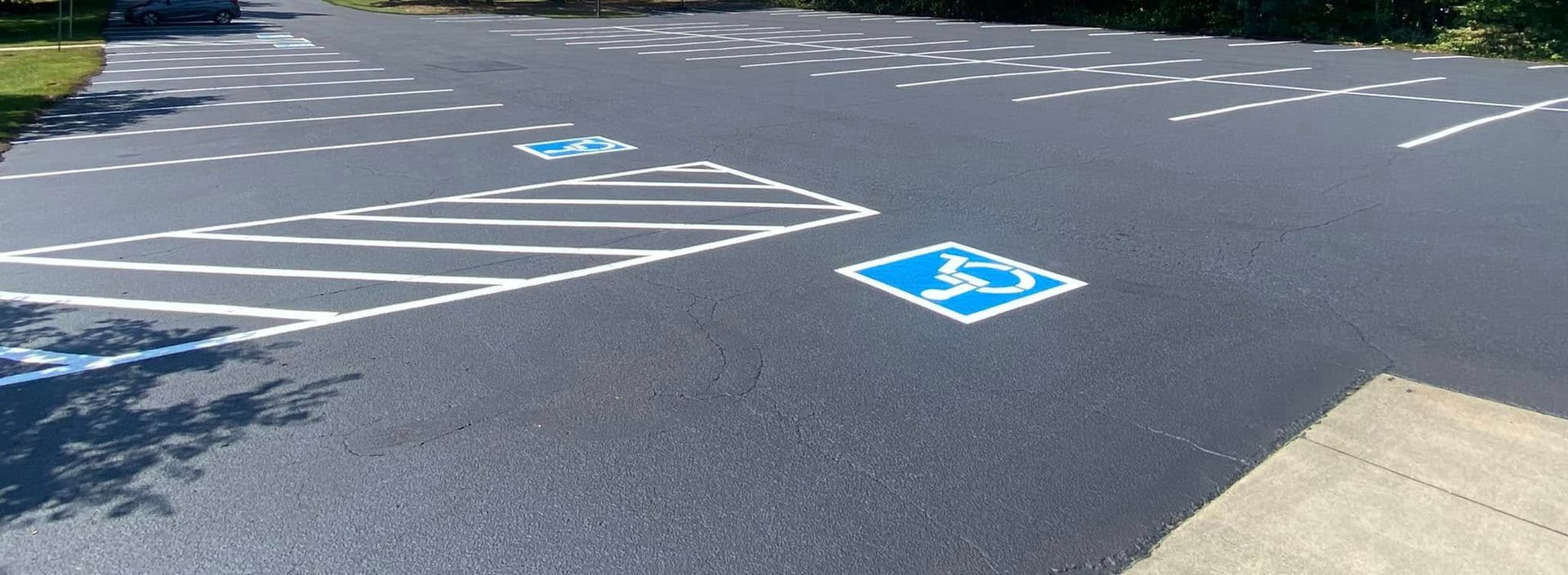 Accessible parking spaces marked in blue and white on an asphalt lot outdoors