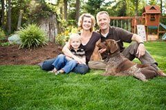 Happy Family with their dog Sitting on the Grass — Pest Control in Chino, CA