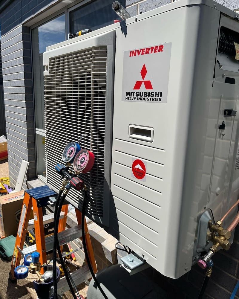 A Mitsubishi Air Conditioner Is Being Installed On The Side Of A Building — AdvancedOne Electrical in Alfredton, VIC