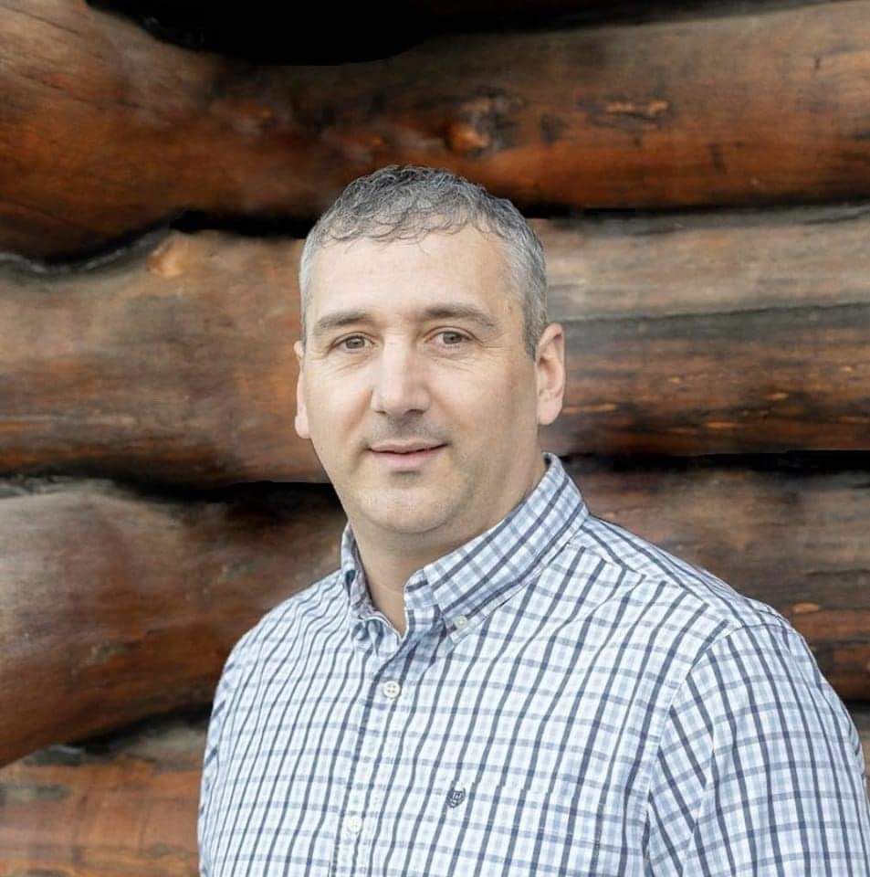 A living room with a couch , chairs , table and fireplace