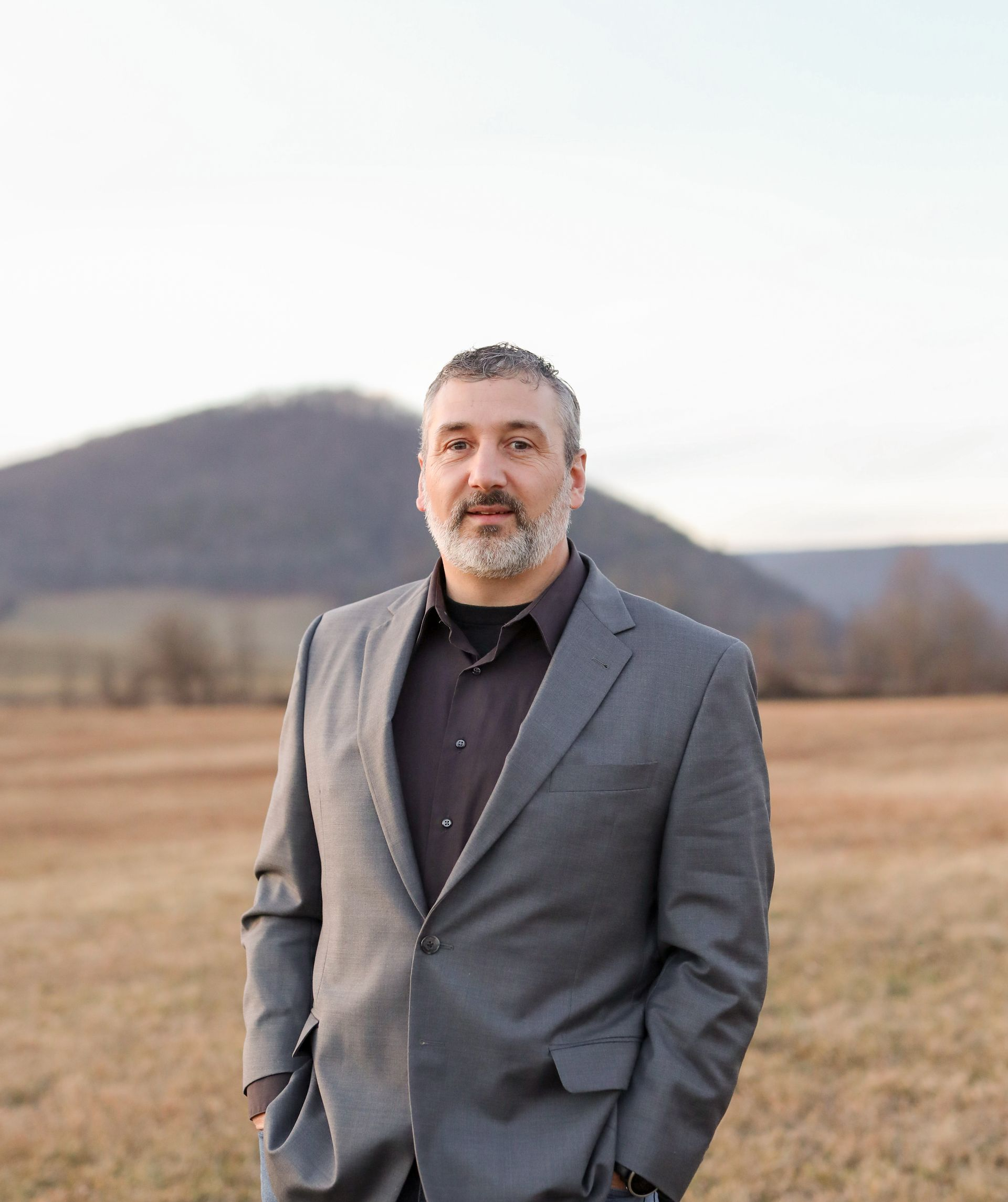 A living room with a couch , chairs , table and fireplace