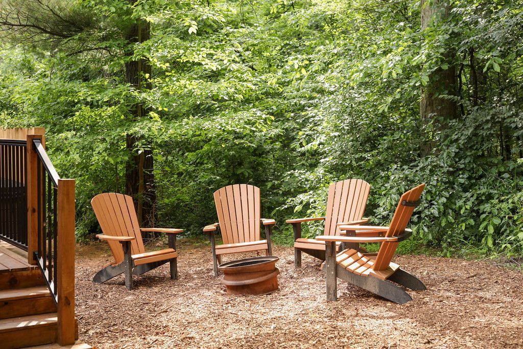 A group of wooden chairs are sitting around a fire pit.